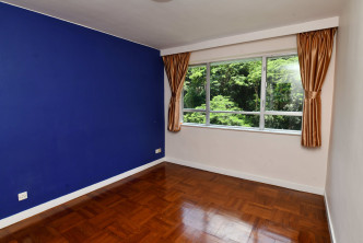 主人房設有闊窗，其中一面牆身以紫藍色布置。