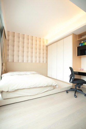 此睡房鋪有偌大牀墊，並於牆身凹位訂製衣櫃及飾櫃，大大增加室內空間感和貯物空間。
