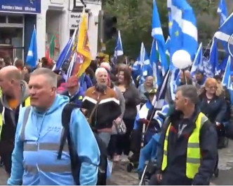 示威抗議者高舉蘇格蘭旗幟穿上蘇格蘭短褶裙吹奏包括風笛等樂器。網圖
