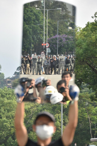 其中一名示威者向警方舉起一塊鏡