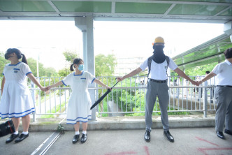 学生于轻铁石排站天桥筑起人链。