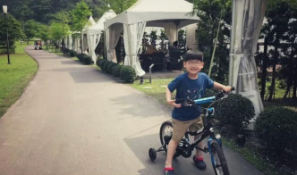 林志颖儿子踩住单车，玩得超开心。