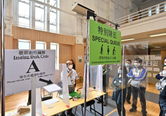 选举事务处向人员讲解票站排队安排。政府新闻处图片