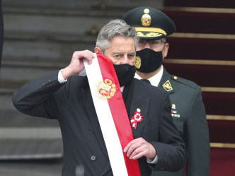 秘鲁前总统萨加斯蒂脱下总统肩带，正式卸任。AP图