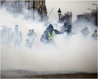 蒙面男子在街上搗亂，防暴警察施放催淚彈驅散群眾。AP