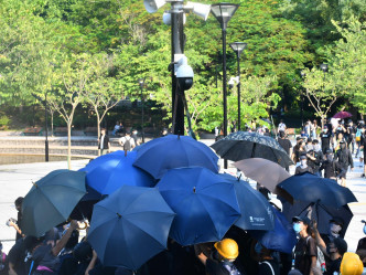 行动期间示威者打开雨伞。