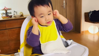 1歲半的Kuson捉住自己耳仔搖頭。