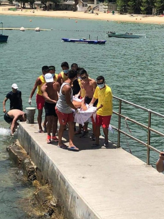 救生员及市民合力把伤势严重的伤者抬上岸。图:港九拯溺员工会