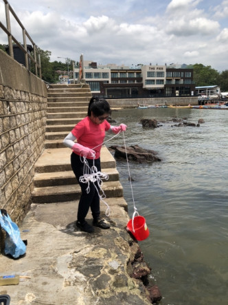 港大博士生楊韻怡在香港仔採集海水樣本。港大圖片