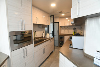 廚房長形間隔，亦設長形工作台及多組白色廚櫃，更備有焗爐等專業廚具。