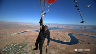 布莱恩手持约50个氦气气球成功升空。 影片截图