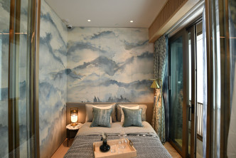以藍白色為主調的主人房，配以山巒牆紙及白雲窗簾。（2座18樓B室經改動示範單位）