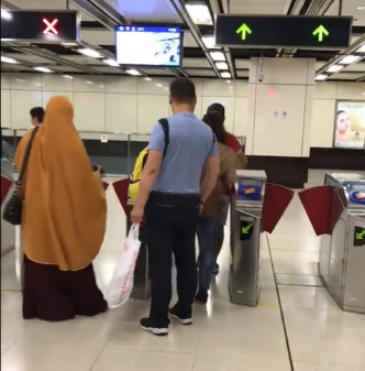 女子尾隨一名男乘客進入閘口。網上圖片