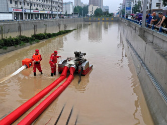 郑州市救援人员抽走路面积水。新华社图片