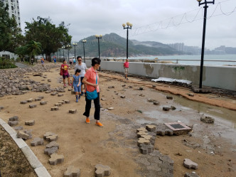海濱長廊磚塊被沖毀，露出散開的沙泥。