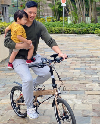 Philip抱着Ryan踩單車。