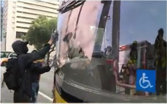 一辆机场巴士被喷漆涂鸦司机位挡风玻璃。NOW新闻截图
