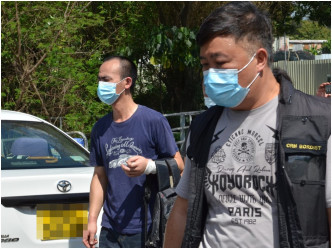 身穿蓝色T恤的另一被困绑的内地男子（左）左手受伤，无须送院。