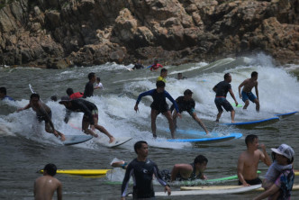 年輕人在大浪灣大玩衝浪。