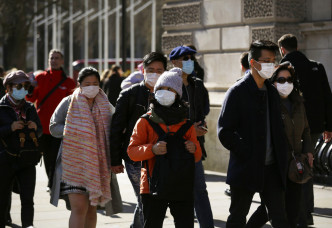 英國市民戴口罩防疫。AP