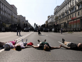 一些婦女在警察封鎖線前面躺在街上。AP