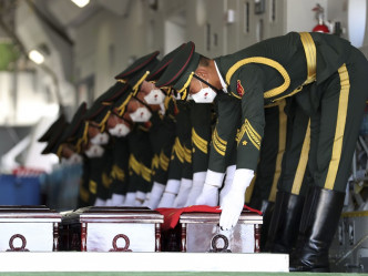 解放军礼兵护送中国士兵棺椁登上空军专机。新华社