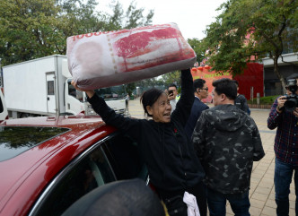 社民连成员手持印有一万亿字样的揽枕，企图走近陈茂波。