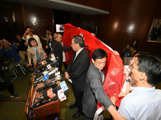 梁君彦会见传媒途中，遇到3名泛民议员到场抗议。