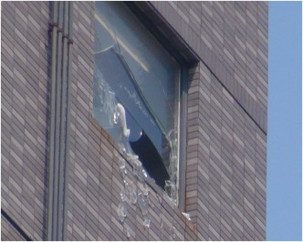 玻璃窗碎片飛墮毗鄰大廈兩車遭殃。林思明攝
