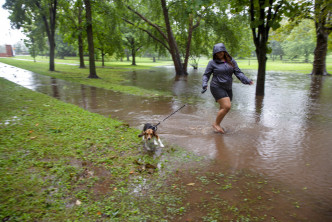 康涅狄格州亦受风暴影响，有人放狗时非常狼狈。AP图片