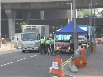 警方设置路障截查驶入卸货区的货车。梁国峰摄