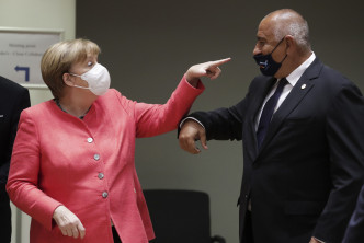 德国总理默克尔（左）看到保加利亚总理鲍里斯索夫口罩滑下来时，假装惊吓地指著对方鼻头。 AP