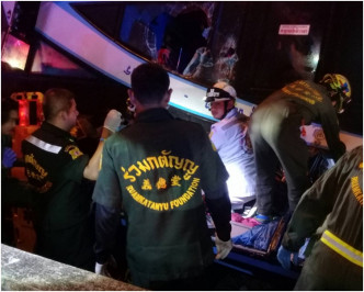 救援人員在翻側的旅巴中救出傷者。