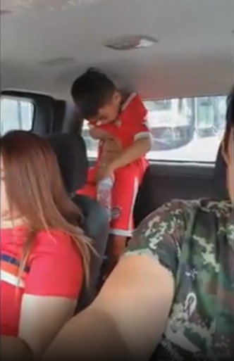 泰国一名尿急男童汽车上手持塑胶瓶解决。网上图片