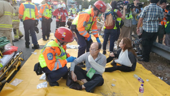 多名傷者坐在路邊待救援。徐裕民攝