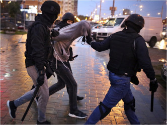 蒙面警员制服示威者，又施放震撼弹及催泪弹驱散群众。AP图片