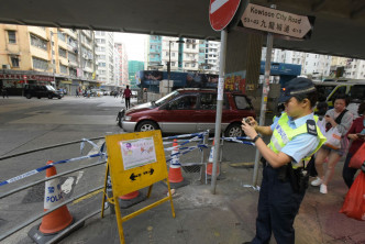 警员竖立告示板提醒注意交通安全。黄文威摄