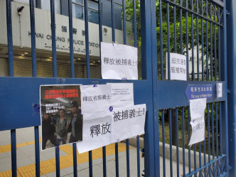 在場聲援的人士在葵涌警署門外大閘上張貼標語，內容大致是「釋放被捕人士」。 梁國峰攝