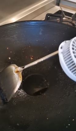 用镬铲不停挤压和翻炒蛋黄，慢慢就会炒出大堆油，冷却后就可入樽。影片截图