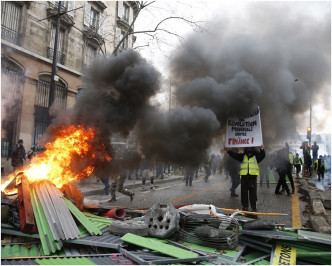 示威者设置临时路障点火烧杂物向防暴警察投掷物件。AP
