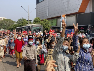 示威者举起泰国民主运动常用的三指抗争手势。AP