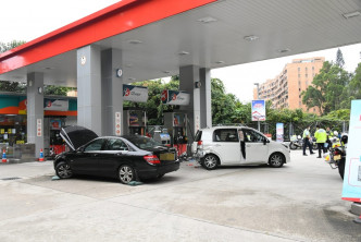 一辆黑色私家车失控铲入油站，撞向白色私家车。