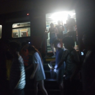 港铁派员安排列车上的乘客摸黑沿路轨行回大埔墟站月台。读者提供