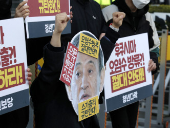 有示威者带上日本首相的面具。AP图片
