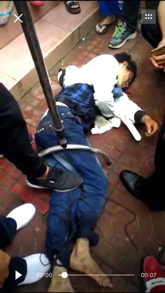 持刀男被警員用鋼叉制服，按倒在地。