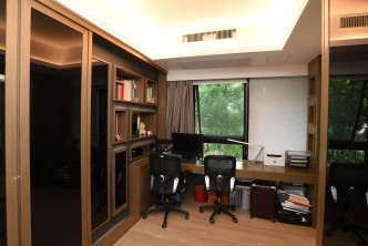 书房采用木系主调，设偌大书桌及多组大柜，工作及贮物空间皆宽阔。