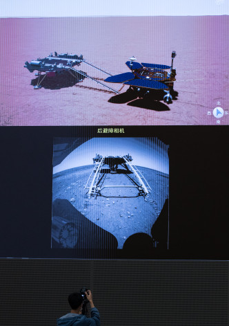 一名工作人員正在拍攝火星車駛離著陸平台畫面。新華社