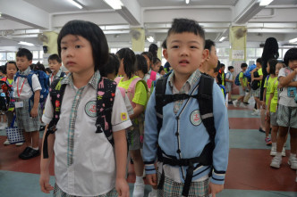 有家长替子女穿上长袖衫开学。