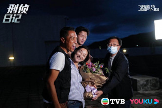 红姐由姜皓文和王浩信伴住，接过监制送的花。