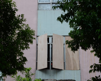 玻璃窗碎裂住戶用木板封住窗口。歐陽偉光攝